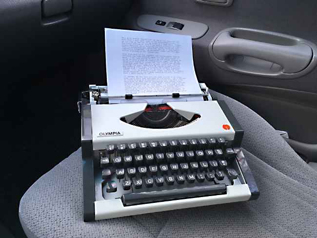A typwriter in the cab of a pickup truck