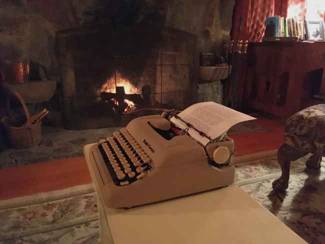 A typewriter by a fireplace
